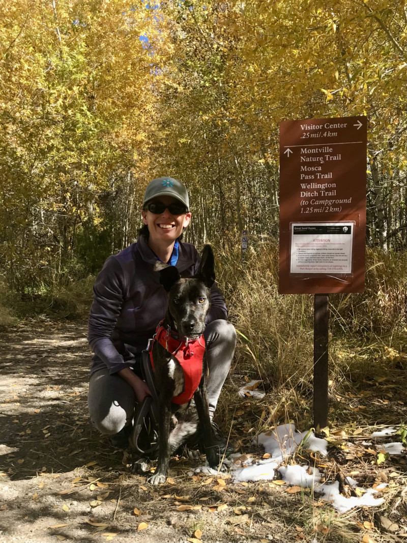 Woman and dog at pet friendly trailhead in Great Sand Dunes National Park in Colorado