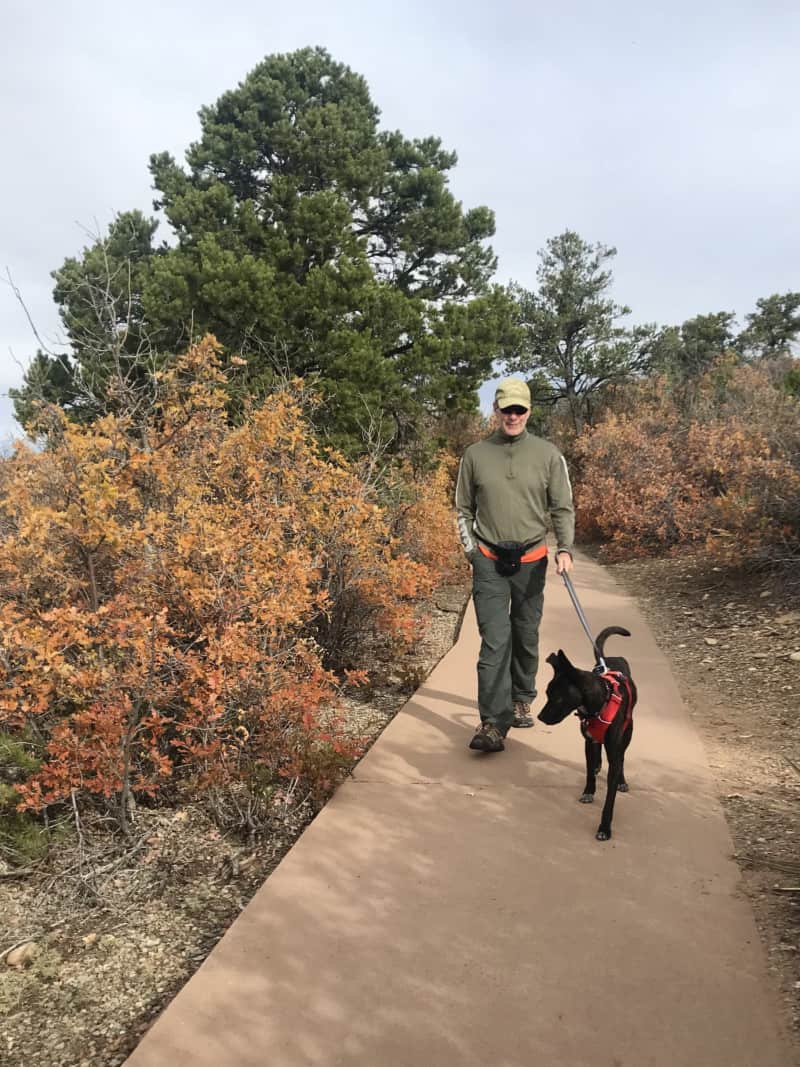 Man walking dog on paved path at Canyon of the Ancients National Monument - Delores, CO