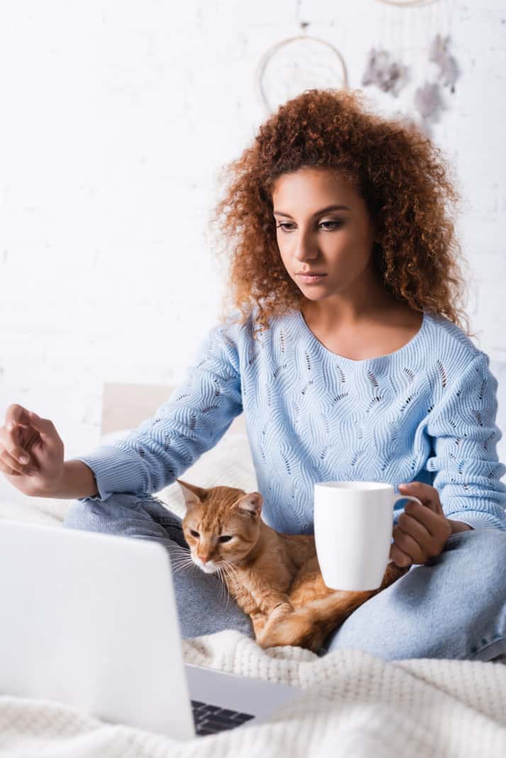 Woman With Cat and Computer on Bed