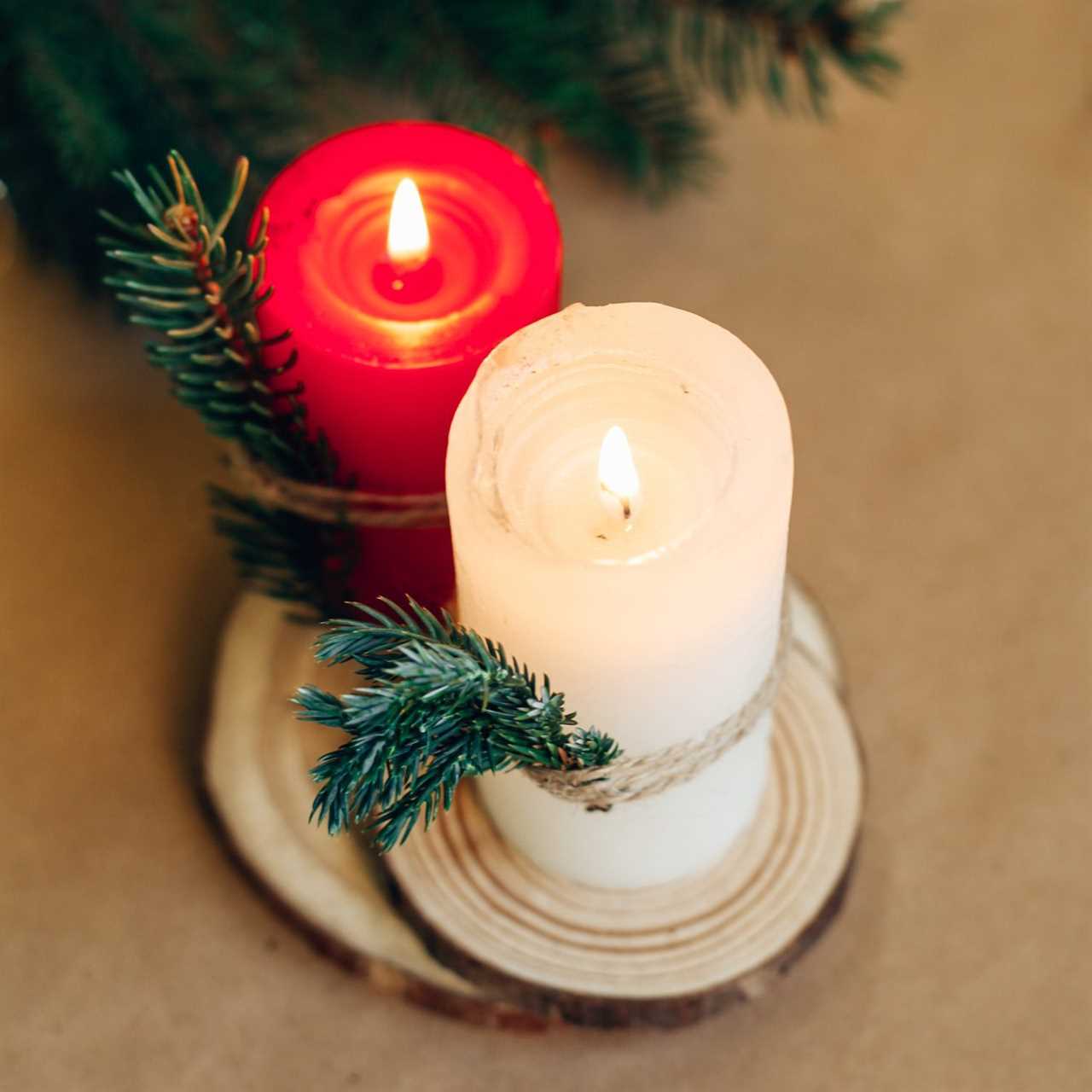 Christmas festive winter greeting card. Red candle, pine branches, wooden natural tray. Home interior decoration.