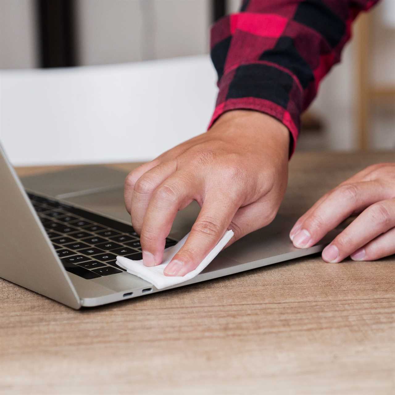 man cleaning his laptop with a laptop cleaning kit