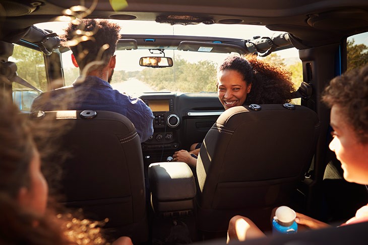 family having fun inside a car while on a road trip