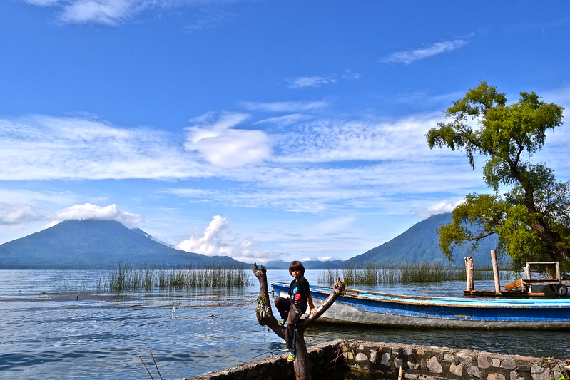 kid sitting on a tree in Lake Atitlan Guatemala