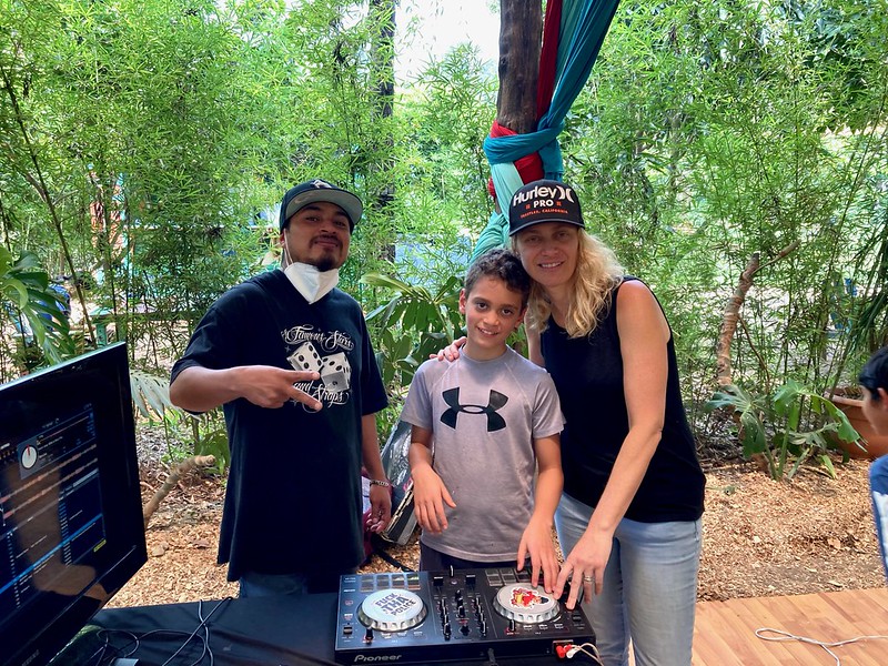 a woman and a kid with a dj and his setup