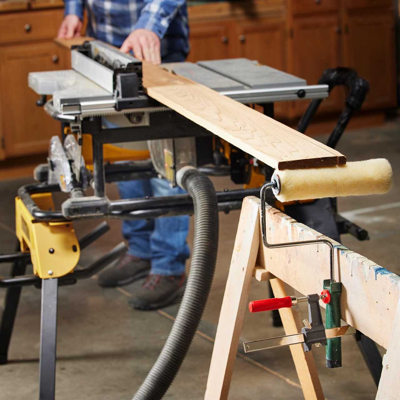 man using paint roller to help cut wood