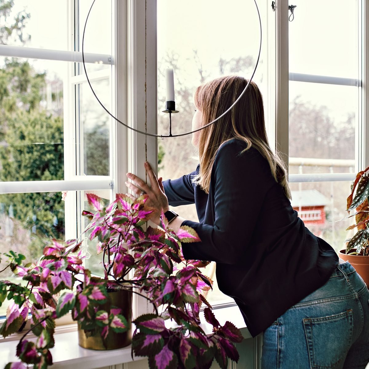 Woman Closing Window In Room At Home