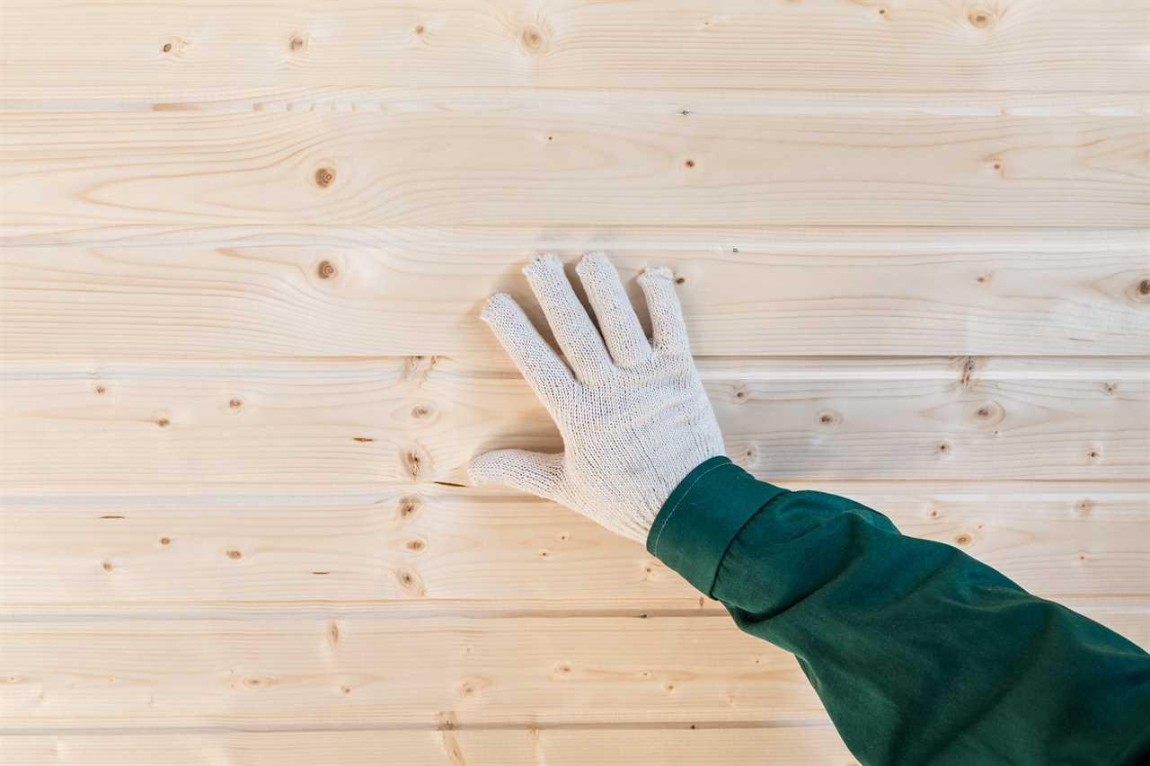 Human palm in gloves on tongue and groove wall