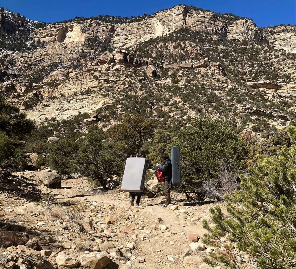 two guys carrying climbing pads in joe's vlley utah