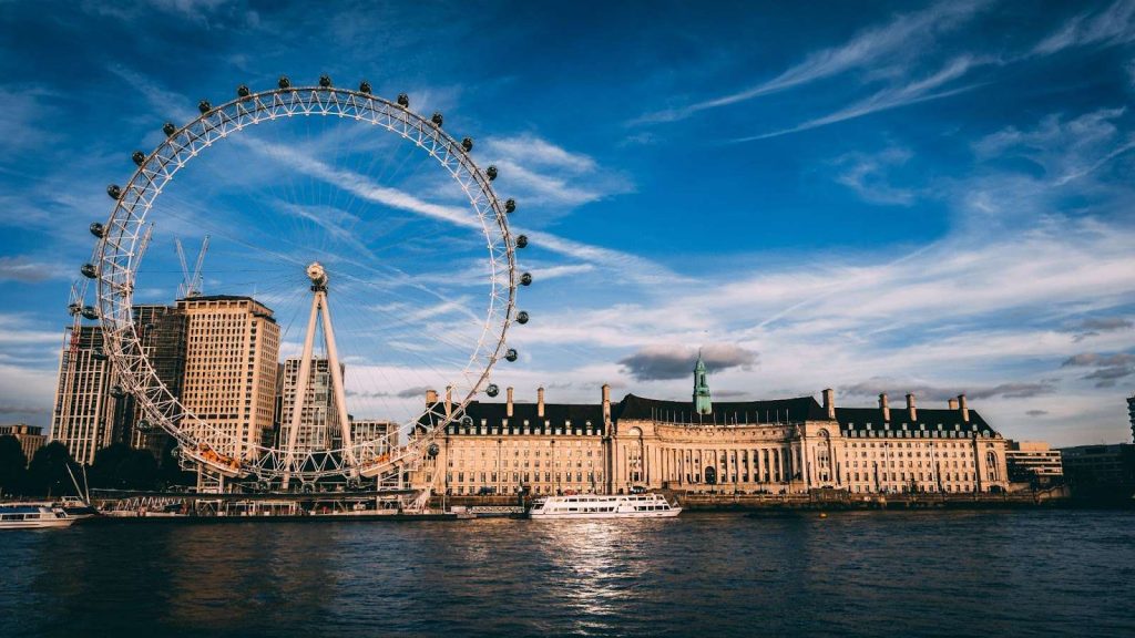 fortune wheel, buildings and a boat on a lake