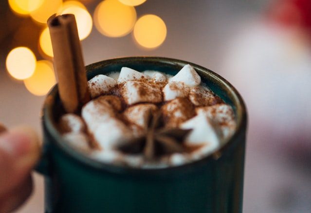 hot chocolate with cinnamon and marshmellows in a cup