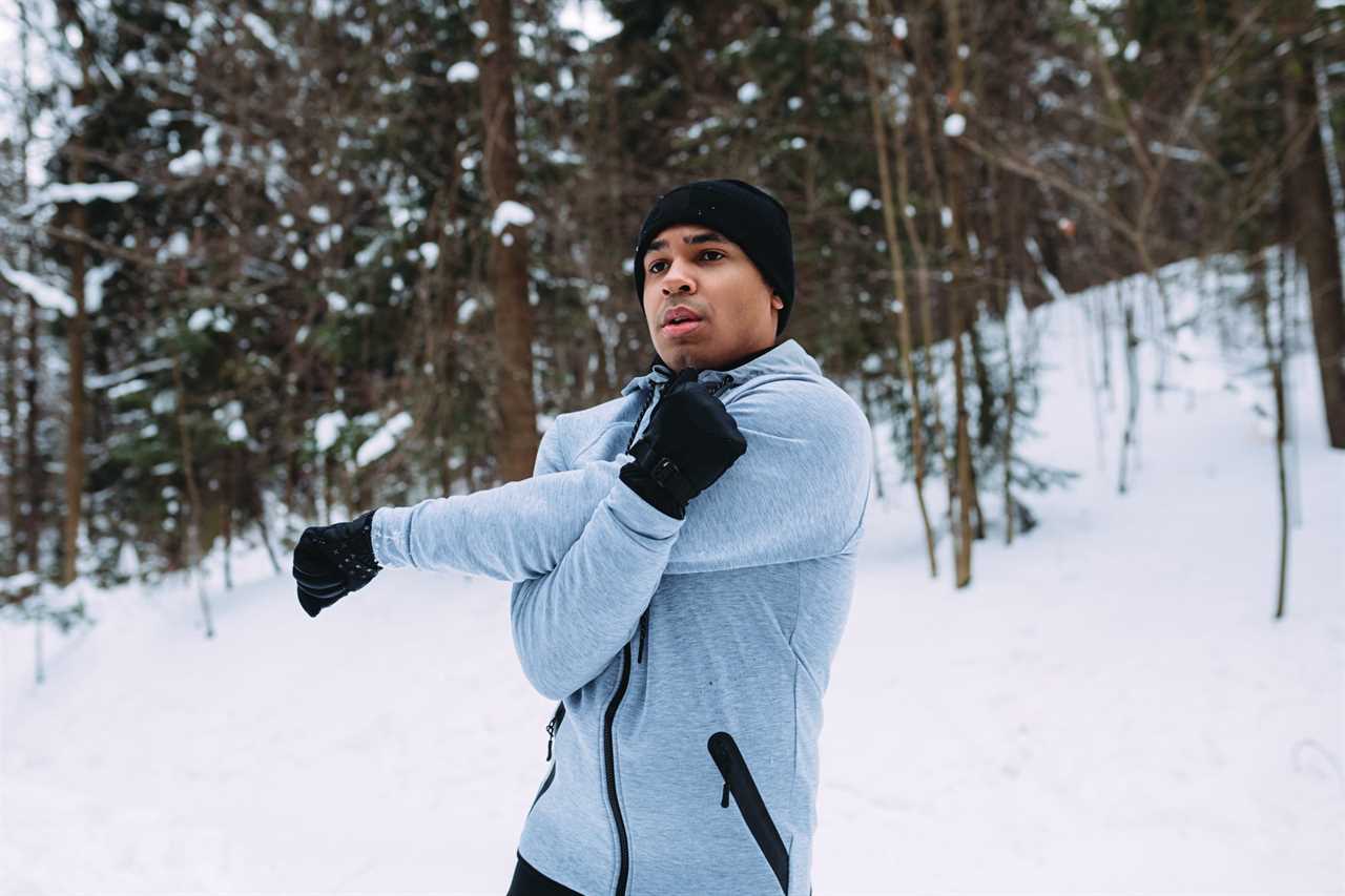 Young Man Exercising While Wearing Warm Clothing During Winter