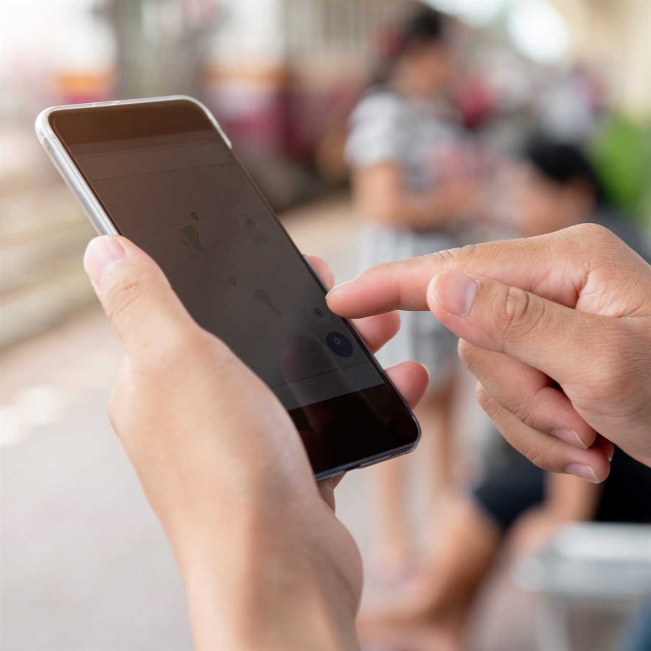 hand holding phone searching where to dispose of antifreeze