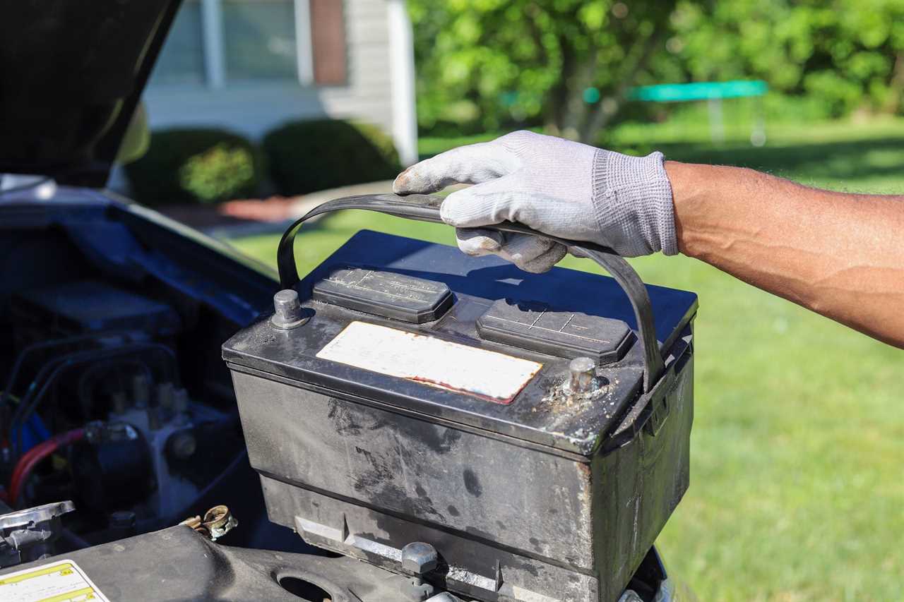 man taking a car battery out of a truck