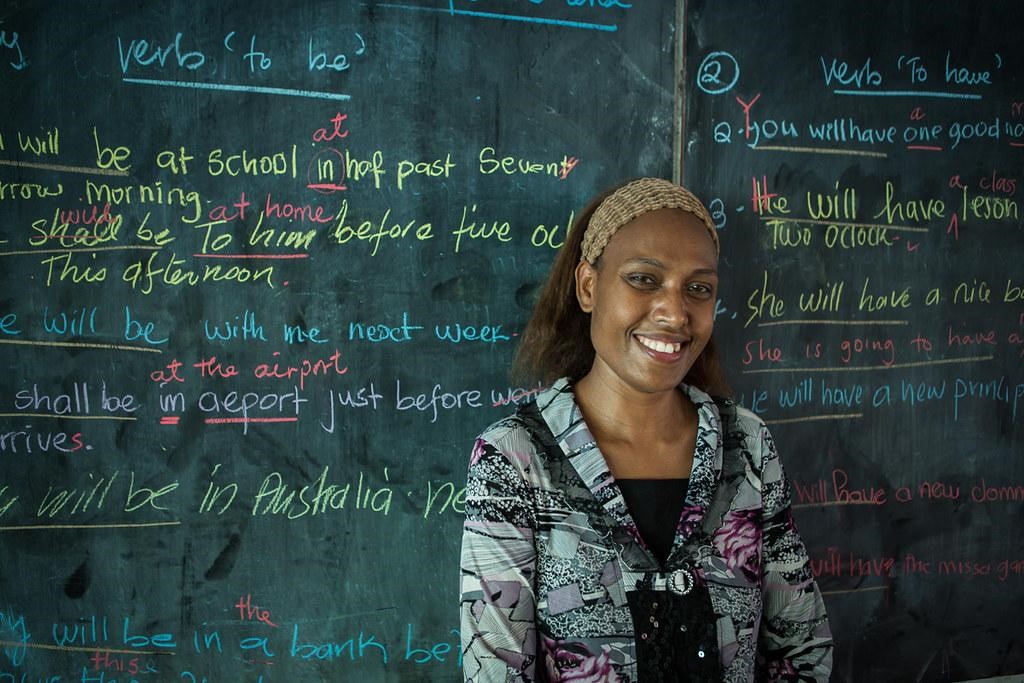 teacher in front of a chalk board