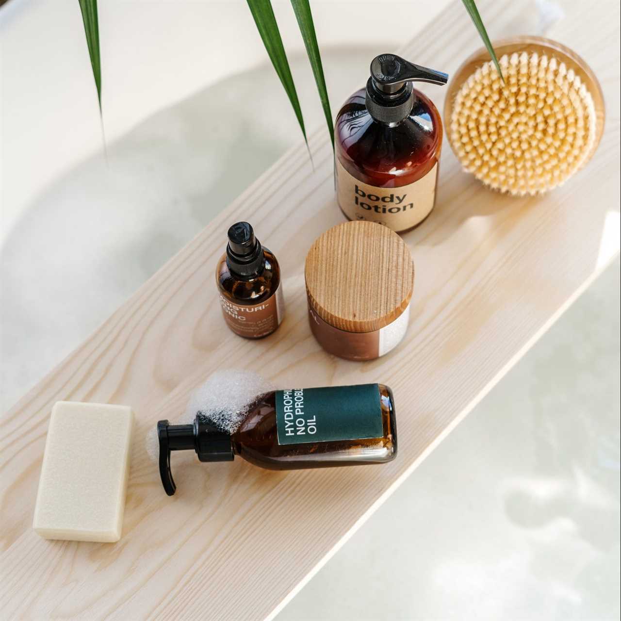 bodycare cosmetics on wooden shelf on bath tub indoors