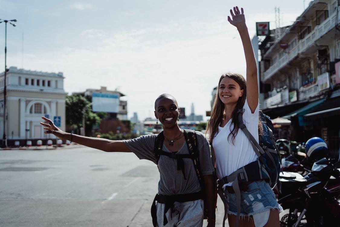 Free Two Women Smiling while Hitchhiking  Stock Photo