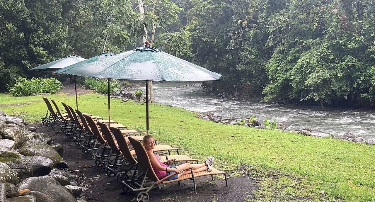 woman lying down next to a river the spring resort costa rica