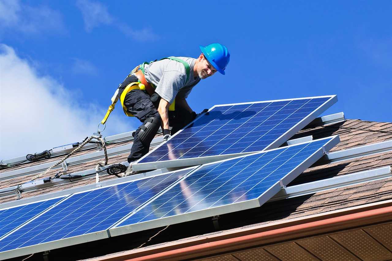 Man installing alternative energy photovoltaic solar panels on roof