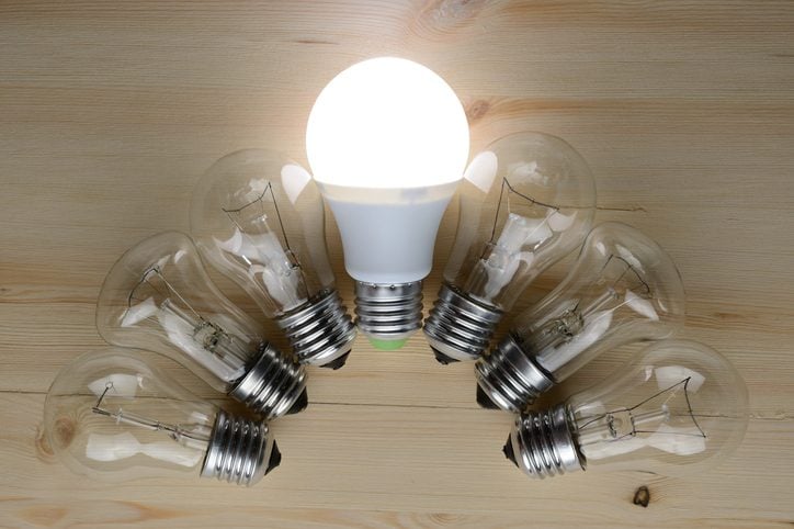 Glowing LED lamp including incandescent lamps on a wooden table