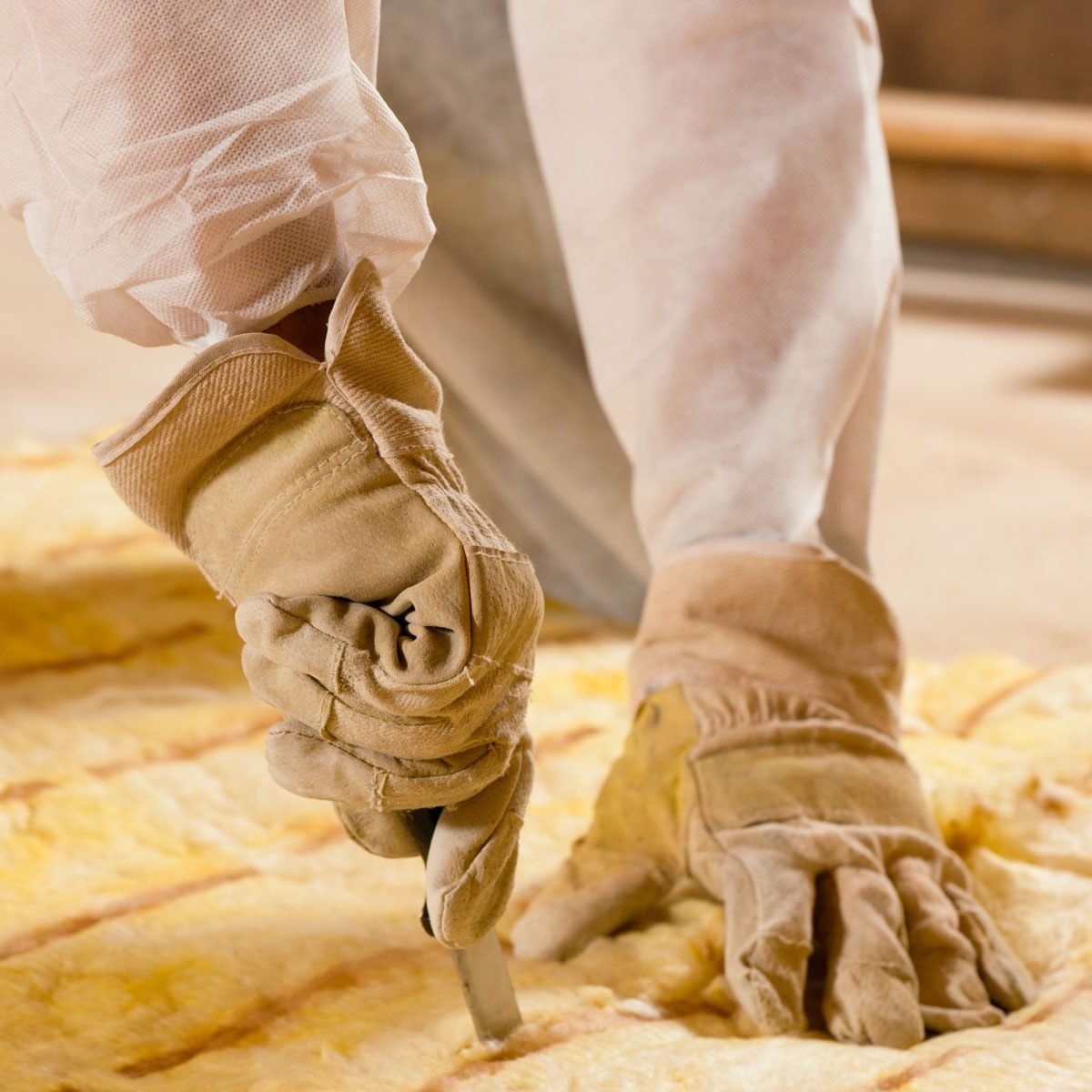 Man Cutting Insulation Material For Building insulation Construction