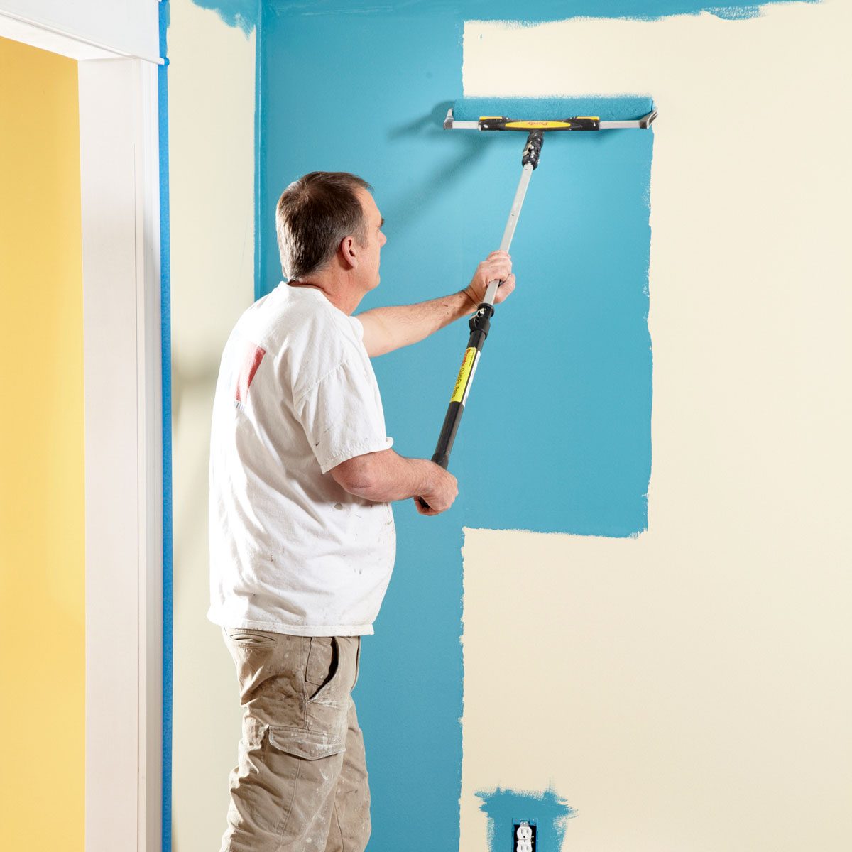 A Man Painting Wall with Extra Wide Roller