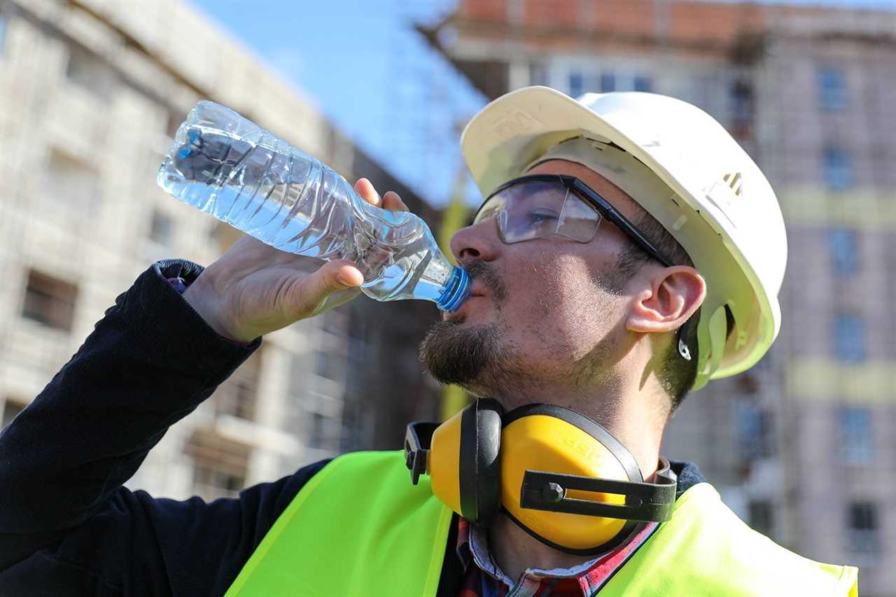 Boss At Construction Site With Bottle Of Water