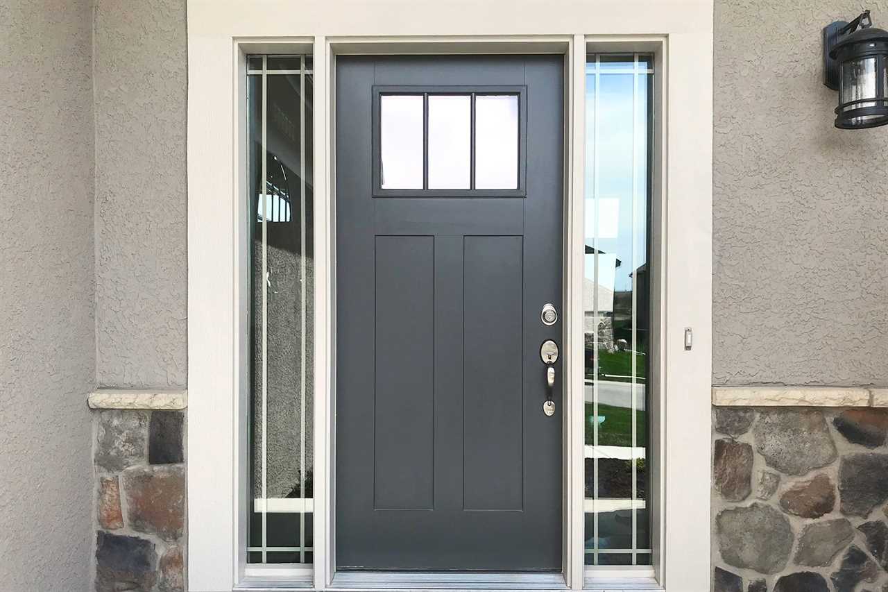 Cement Gray Front Door with white trim, windows on both sides of the door, stucco siding and rock stone pattern stuck to the front of the home