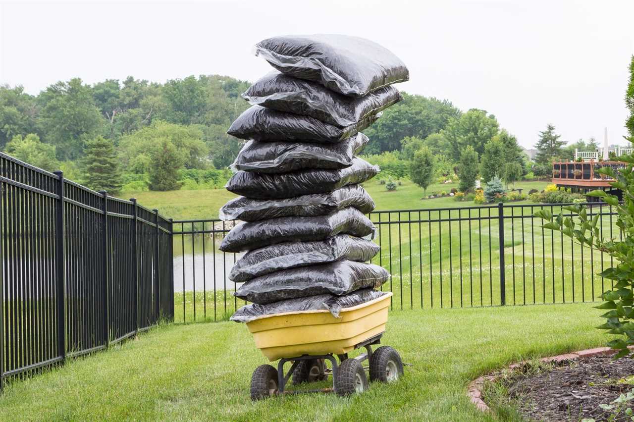 Mulch bags piled high on a cart in the garden