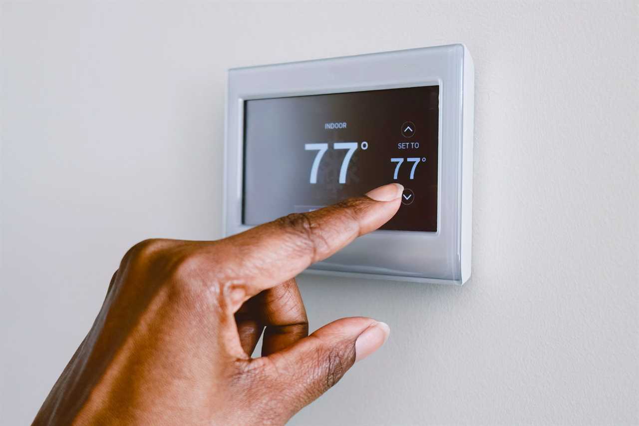Close-up of unrecognizable black woman adjusting thermostat